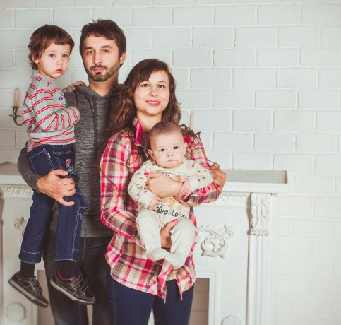 A joyful family posing together in a cozy living room, embodying love and togetherness.